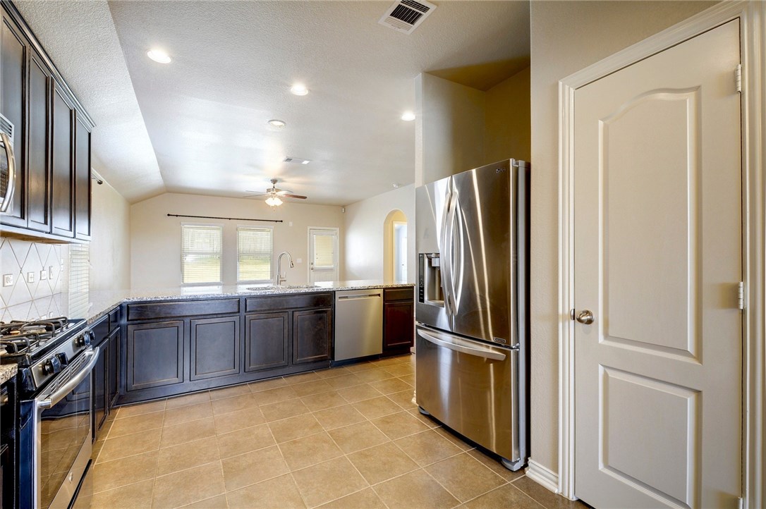 3621 Rams Horn Way Round Rock, TX 78665 - Photo 10 of 24 a kitchen with stainless steel appliances granite countertop a refrigerator and a stove top oven