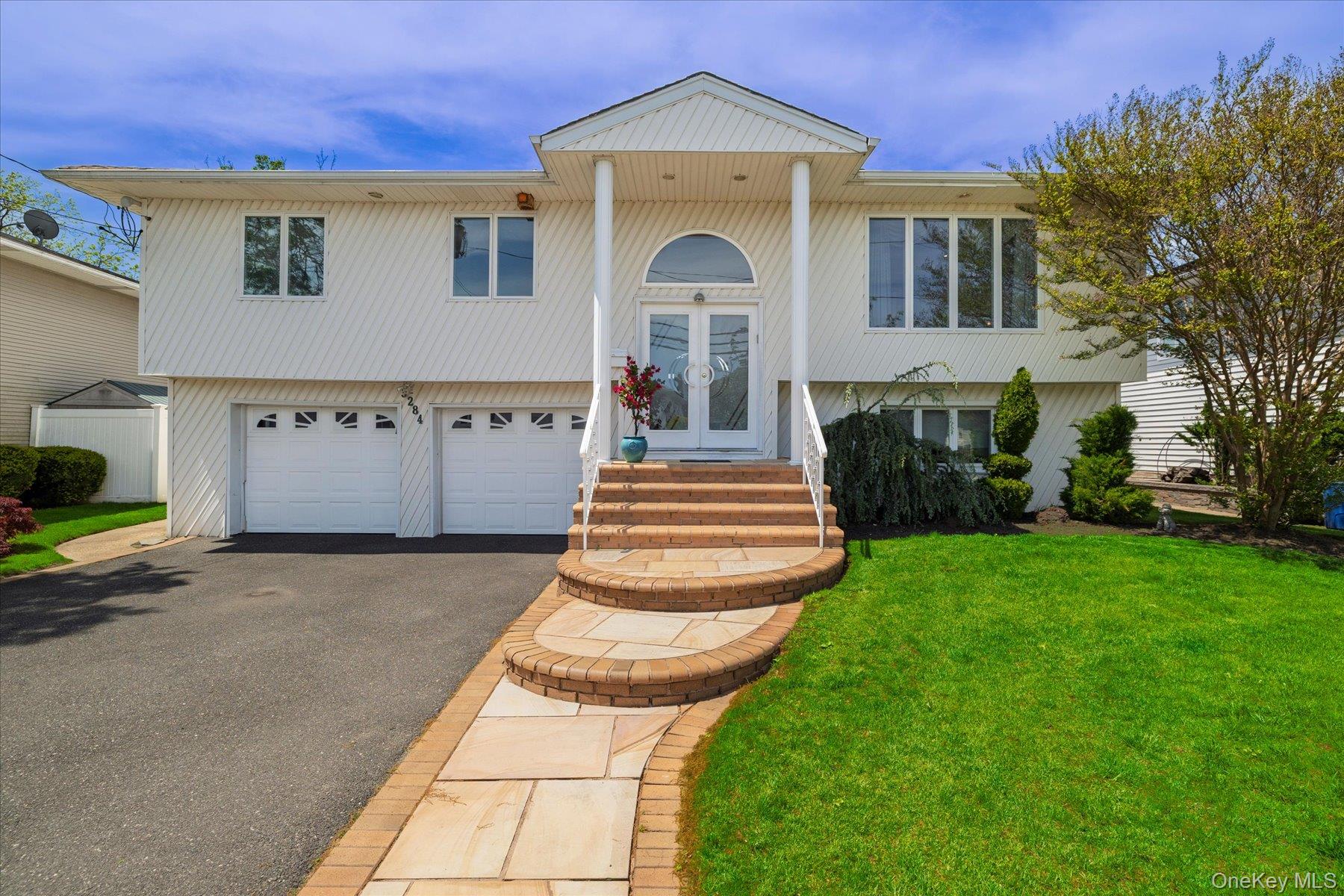 3284 Shore Road Oceanside, NY 11572 - Photo 1 of 27 a front view of a house with a garden