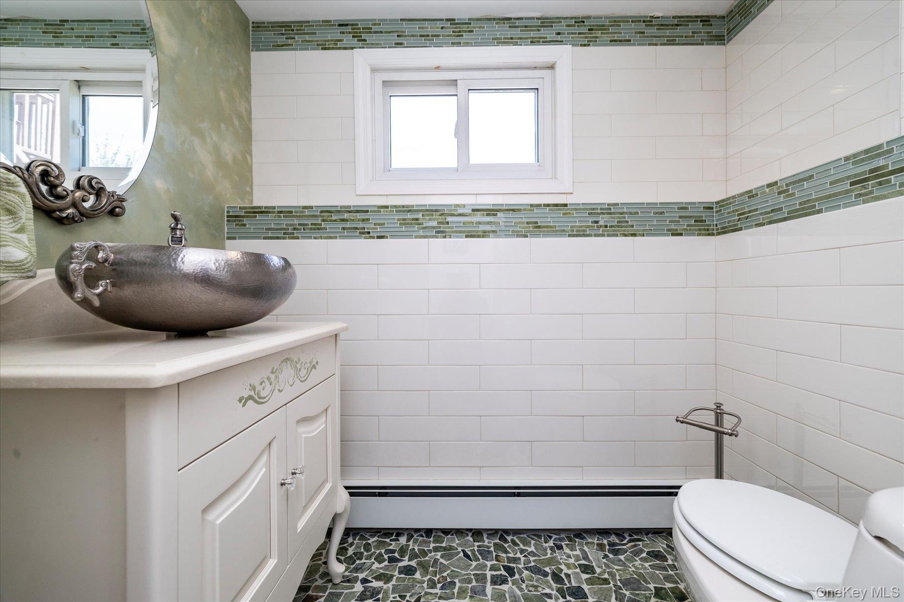 3284 Shore Road Oceanside, NY 11572 - Photo 18 of 27 a bathroom with a sink a toilet and mirror