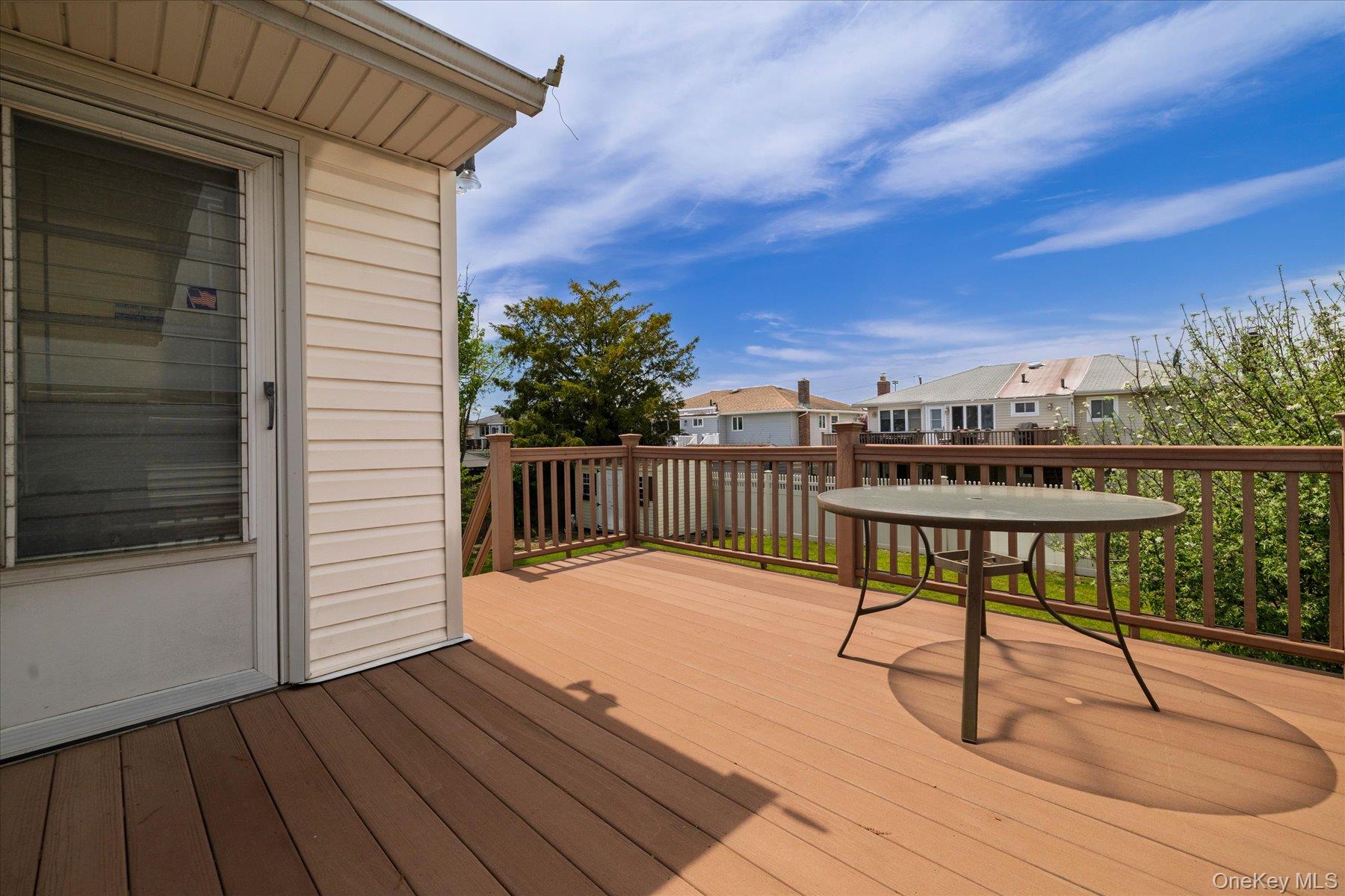 3284 Shore Road Oceanside, NY 11572 - Photo 25 of 27 a balcony with wooden floor table and chairs