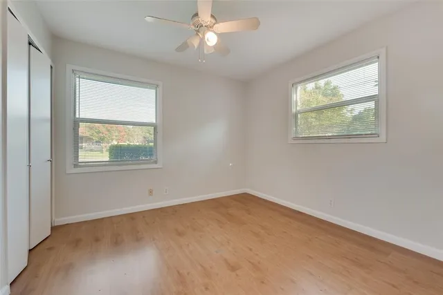 an empty room with a window and ceiling fan