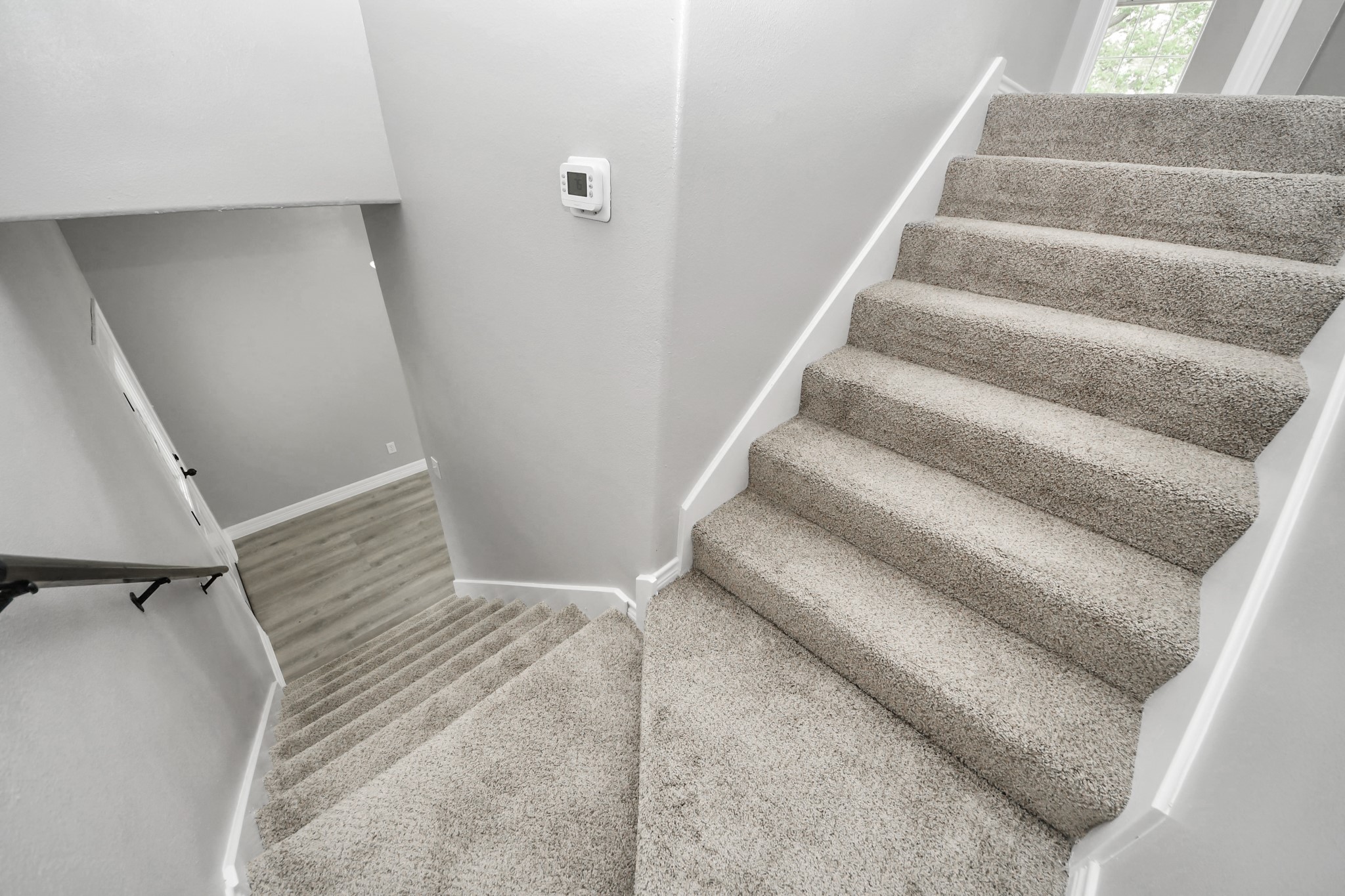1105 East Kyle Road Clute, TX 77531 - Photo 17 of 44 The staircase leading upstairs with new carpeting and a new thermostat is mounted on the wall.