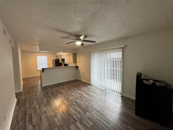 a view of a livingroom with a flesh screen tv and wooden floor