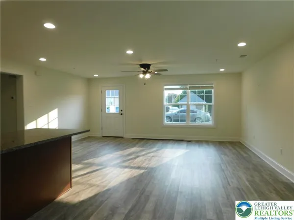 an empty room with windows cabinet and fireplace