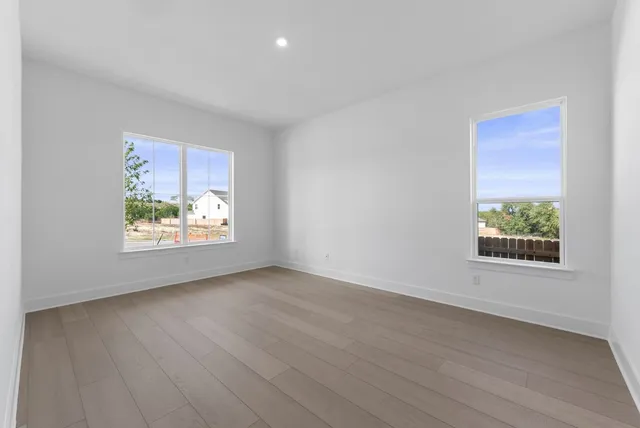 an empty room with wooden floor and window