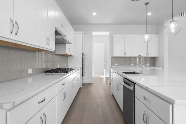 a large kitchen with stainless steel appliances granite countertop a sink a stove and a refrigerator