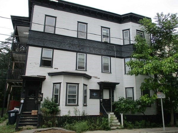 a large white building with potted plants in front of it