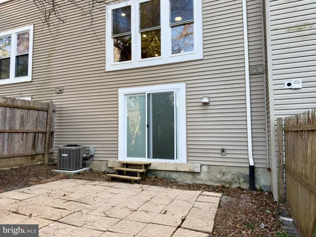 a view of a brick house with windows and yard in back