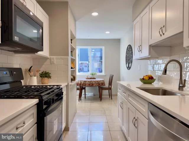 a kitchen with granite countertop a sink a stove and cabinets