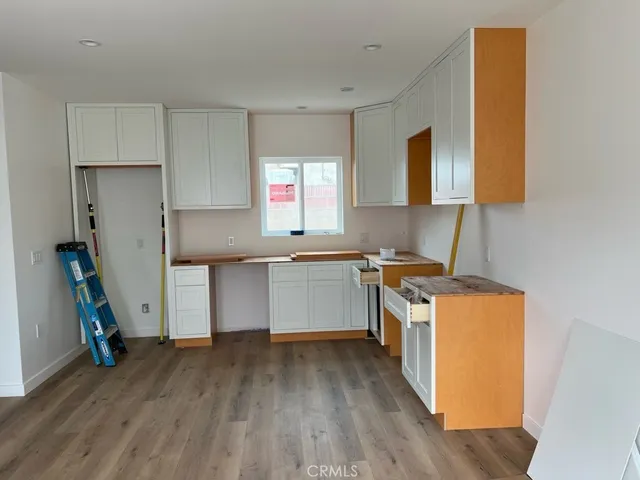 a kitchen with a sink and wooden floor