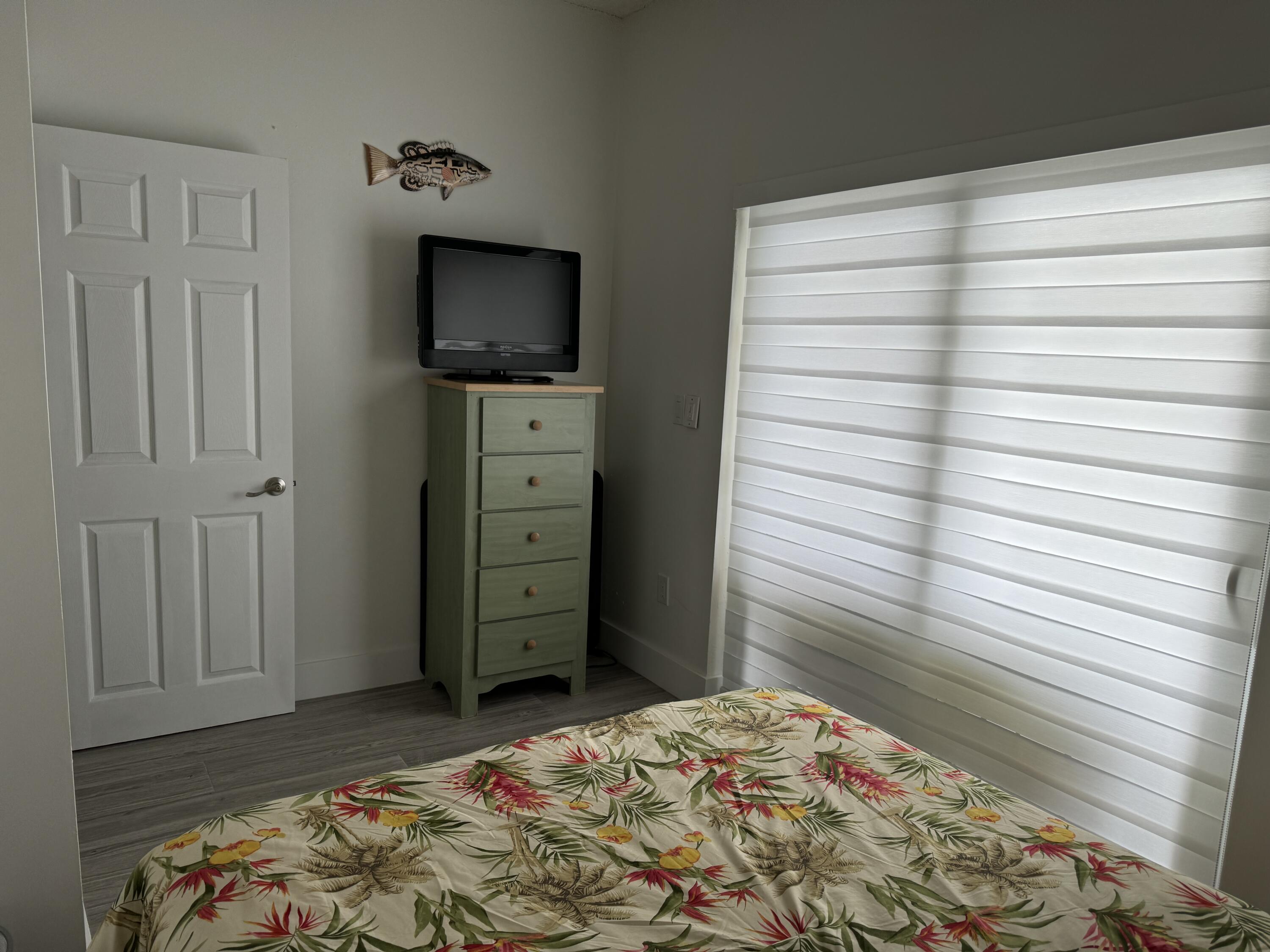 176 Lorelane Place Key Largo, FL 33037 - Photo 11 of 20 a bedroom with a bed and a flat screen tv