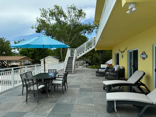 a view of a patio with a table and chairs under an umbrella