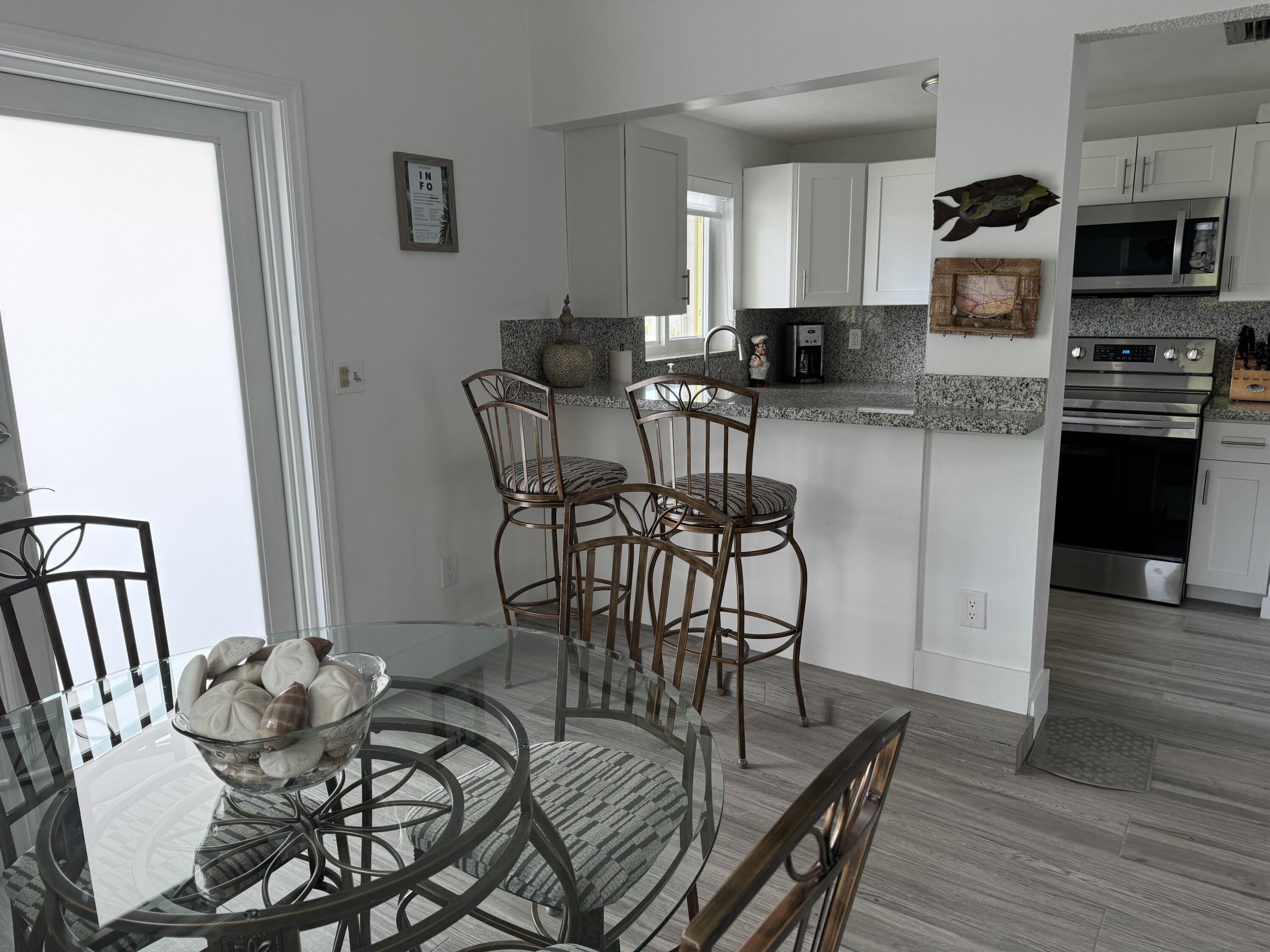 176 Lorelane Place Key Largo, FL 33037 - Photo 10 of 20 a kitchen with stainless steel appliances kitchen island granite countertop a table chairs in it and a window