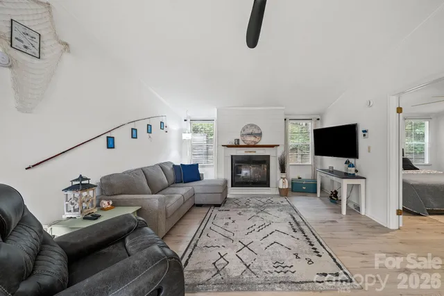 a living room with furniture a flat screen tv and a fireplace