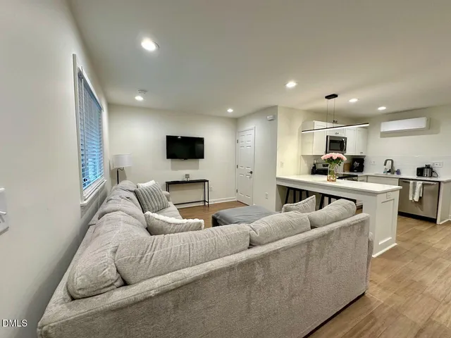 a living room with furniture and kitchen view