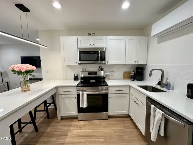a kitchen with a stove cabinets and a dining table