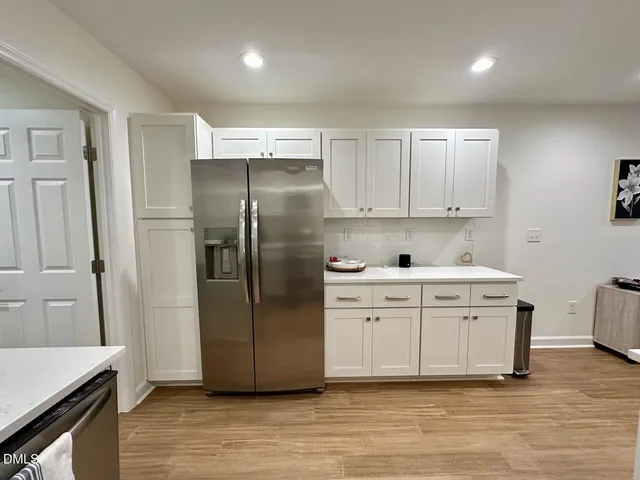 a kitchen with a refrigerator sink and cabinets