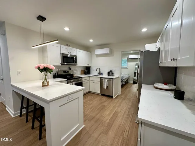 a kitchen with a sink a counter top space appliances and cabinets