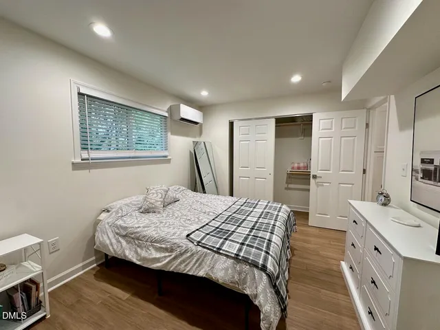 a bedroom with a bed and a refrigerator