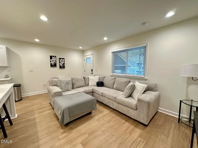 a living room with furniture and a wooden floor