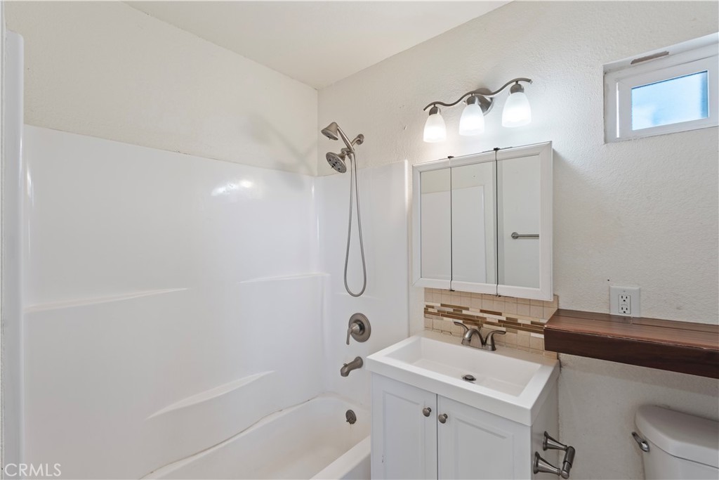23859 S Road Apple Valley, CA 92307 - Photo 15 of 45 a bathroom with a sink a toilet a mirror and shower