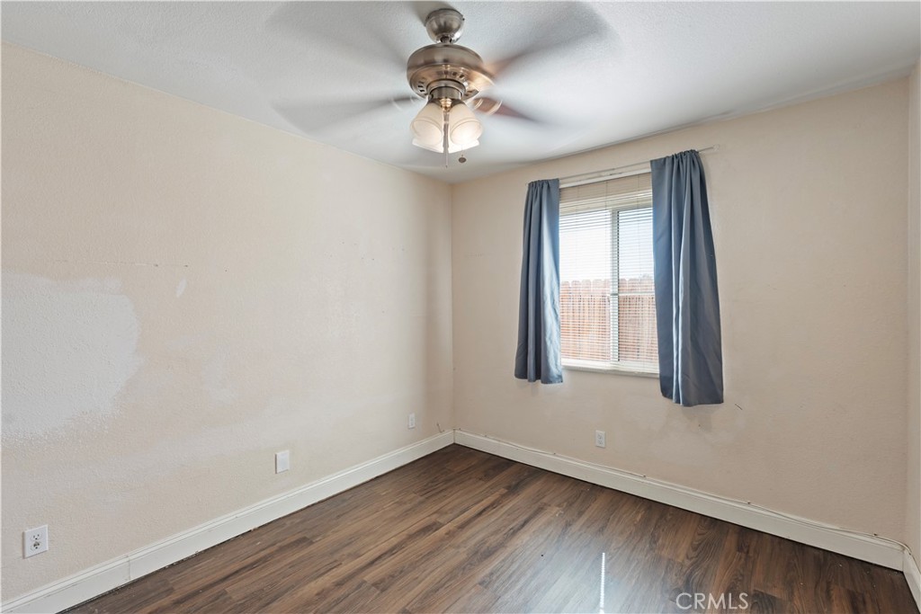 23859 S Road Apple Valley, CA 92307 - Photo 18 of 45 a view of an empty room with wooden floor and a window