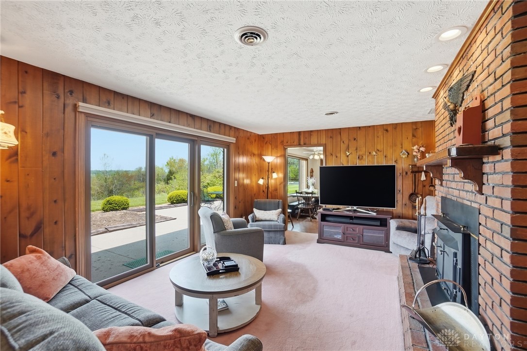 5669 O Neall Road Waynesville, OH 45068 - Photo 29 of 72 This inviting living room features a charming brick fireplace and expansive sliding doors opening to scenic views.