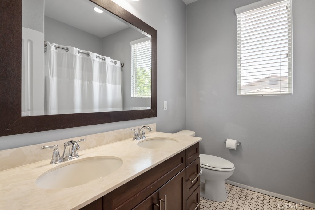 29463 Bouris Drive Menifee, CA 92584 - Photo 14 of 26 a bathroom with a granite countertop sink toilet and mirror