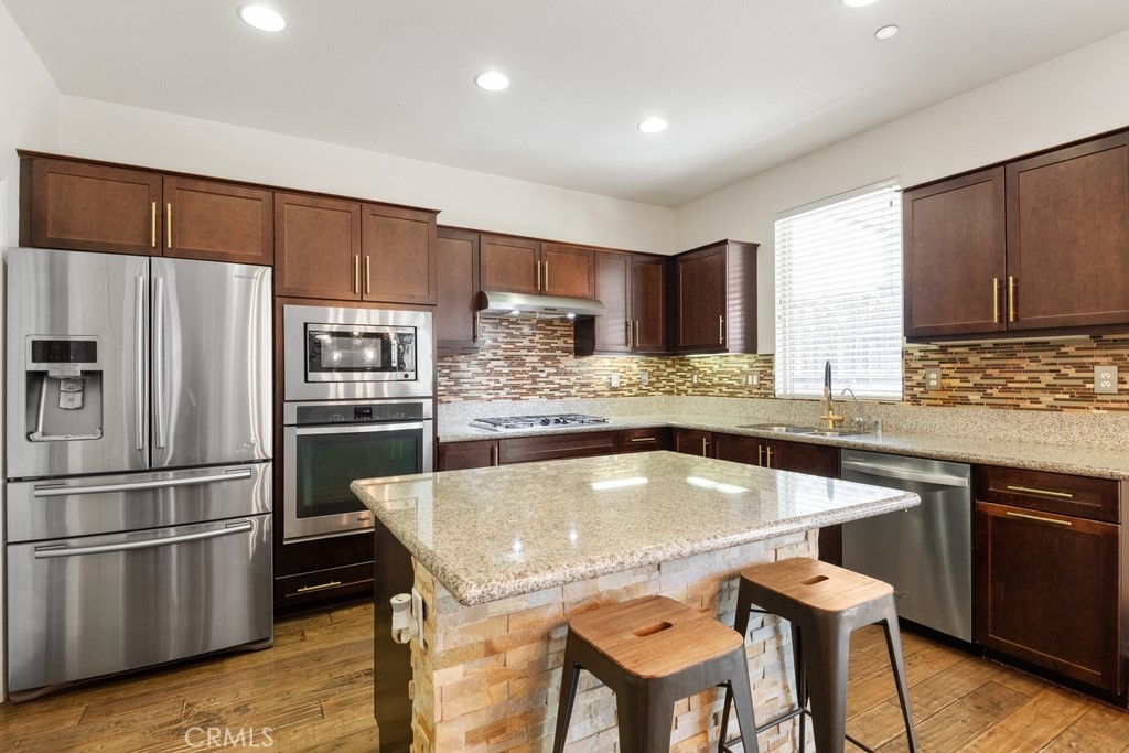 29463 Bouris Drive Menifee, CA 92584 - Photo 5 of 26 a kitchen with granite countertop a sink appliances cabinets and counter space