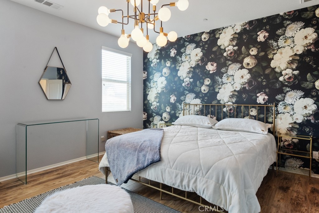 29463 Bouris Drive Menifee, CA 92584 - Photo 8 of 26 a bedroom with a bed lamp and a chandelier