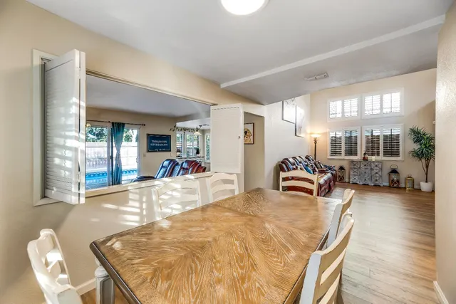 a view of a dining room and livingroom with furniture wooden floor a chandelier