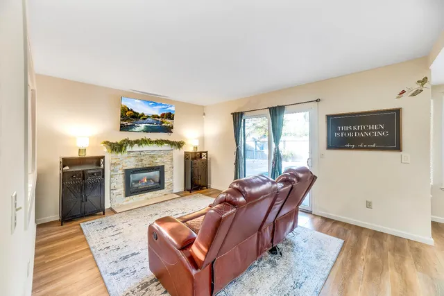 a living room with furniture a fireplace and wooden floor