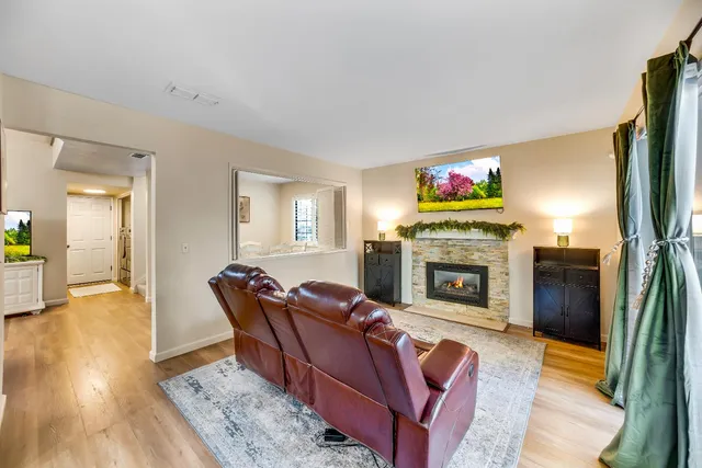 a living room with furniture a flat screen tv and a fireplace