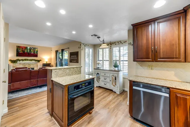 a kitchen with stainless steel appliances granite countertop wooden floors and sink