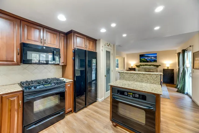 a kitchen with stainless steel appliances granite countertop a stove microwave and refrigerator