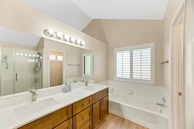 a bathroom with double vanity sink and a mirror