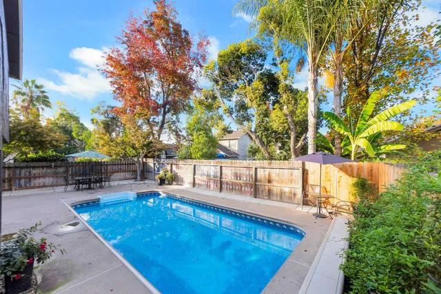 a view of a swimming pool with a patio and a yard