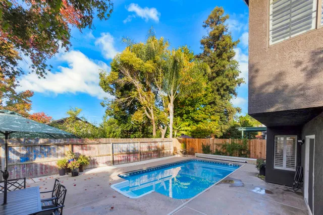 a view of a house with swimming pool and sitting area