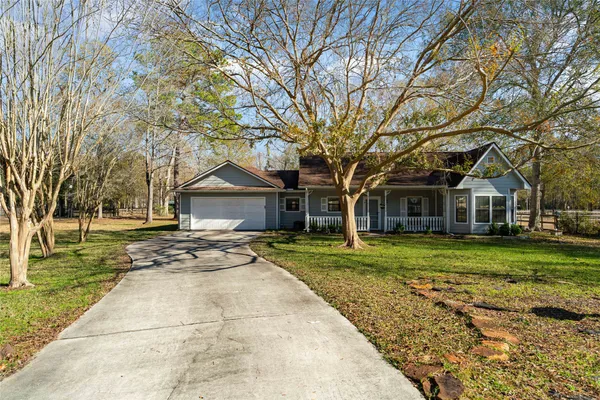 a front view of a house with a yard and trees