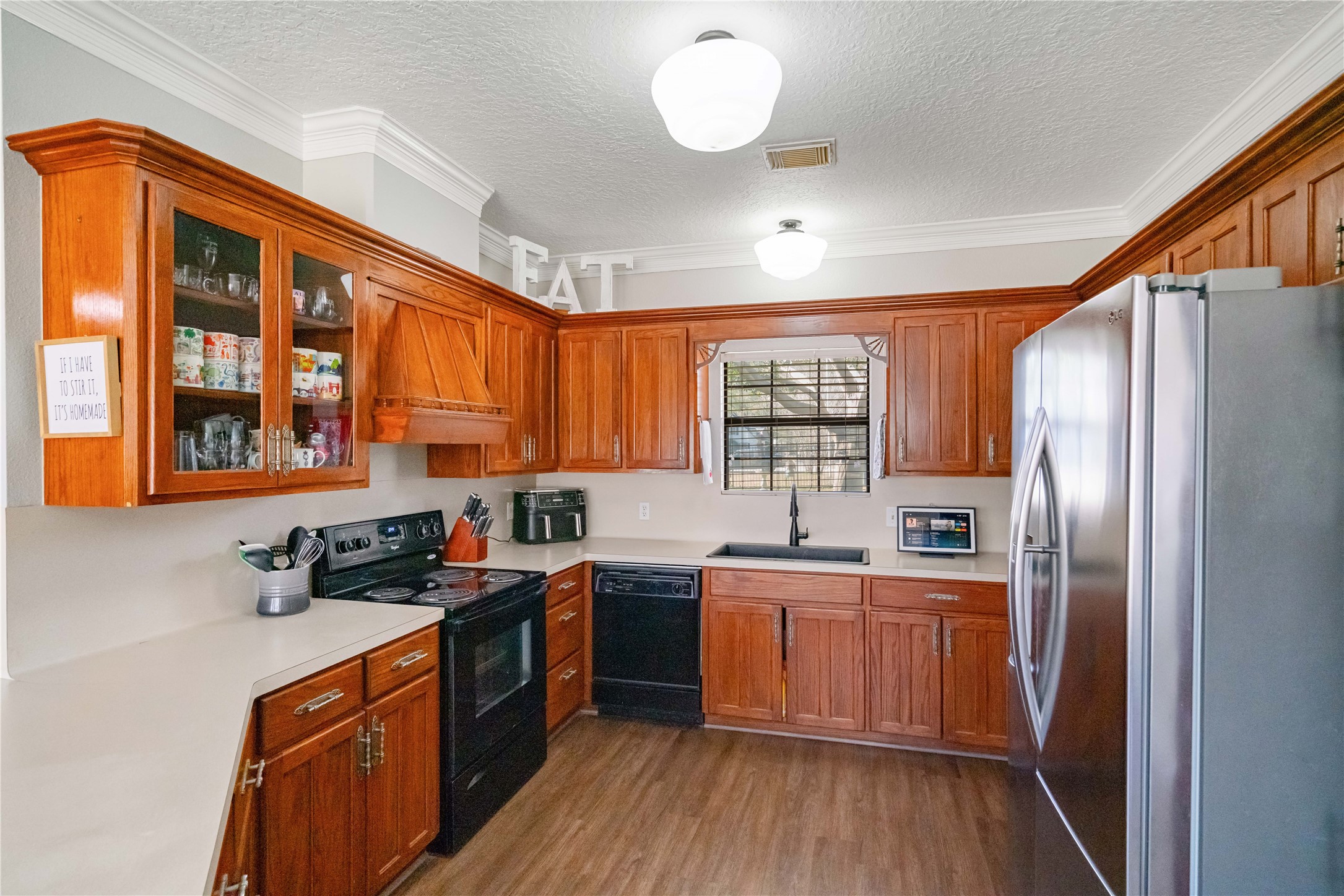 28911 Commons Oaks Drive Huffman, TX 77336 - Photo 12 of 26 a kitchen with stainless steel appliances granite countertop a stove a sink dishwasher a refrigerator and cabinets with wooden floor