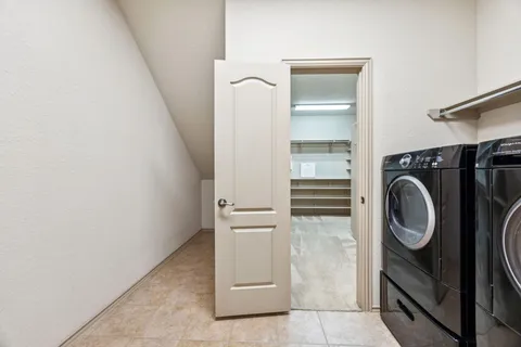 a view of a storage and utility room with washer and dryer