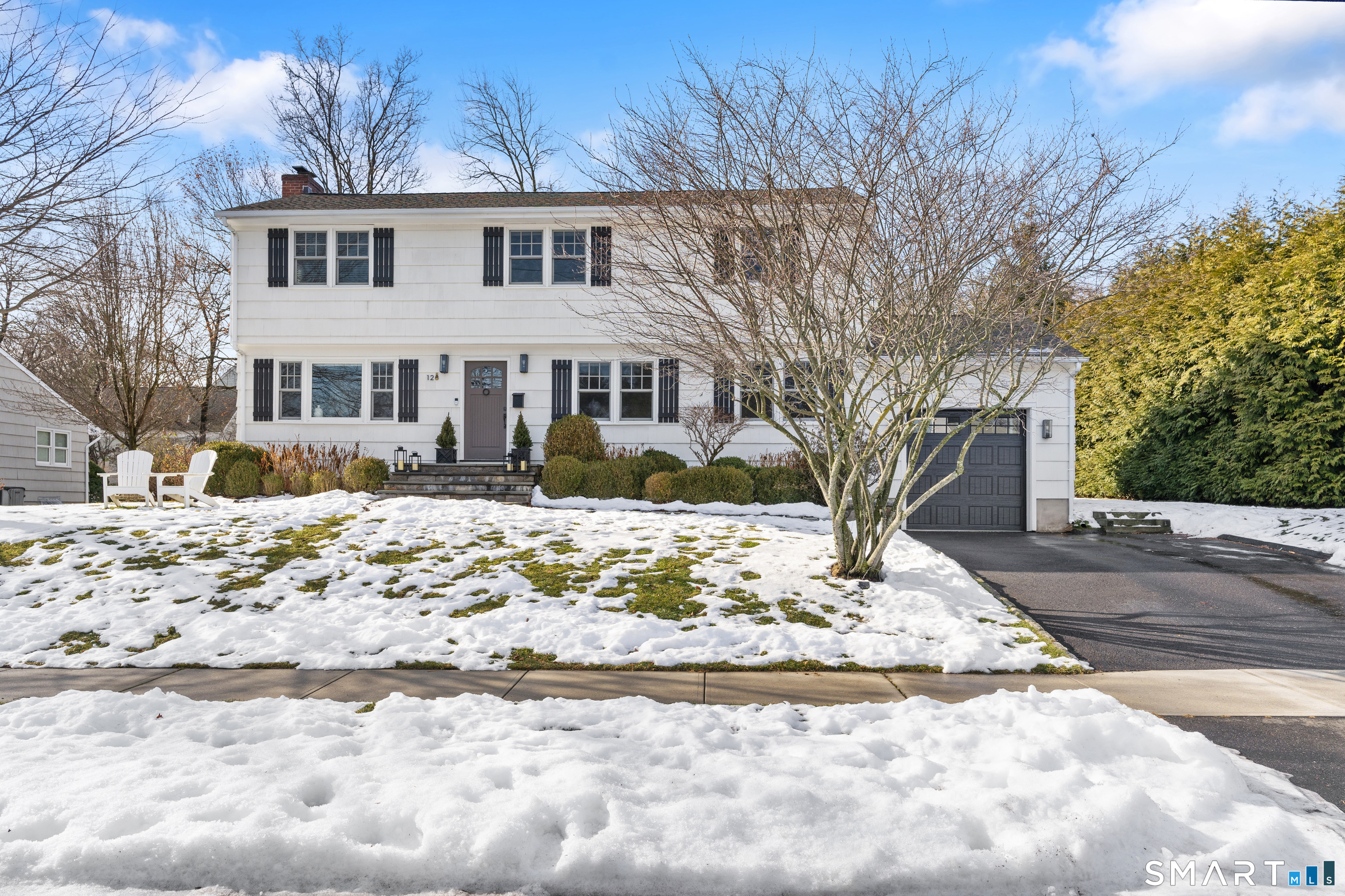 a front view of a house with a yard covered in snow