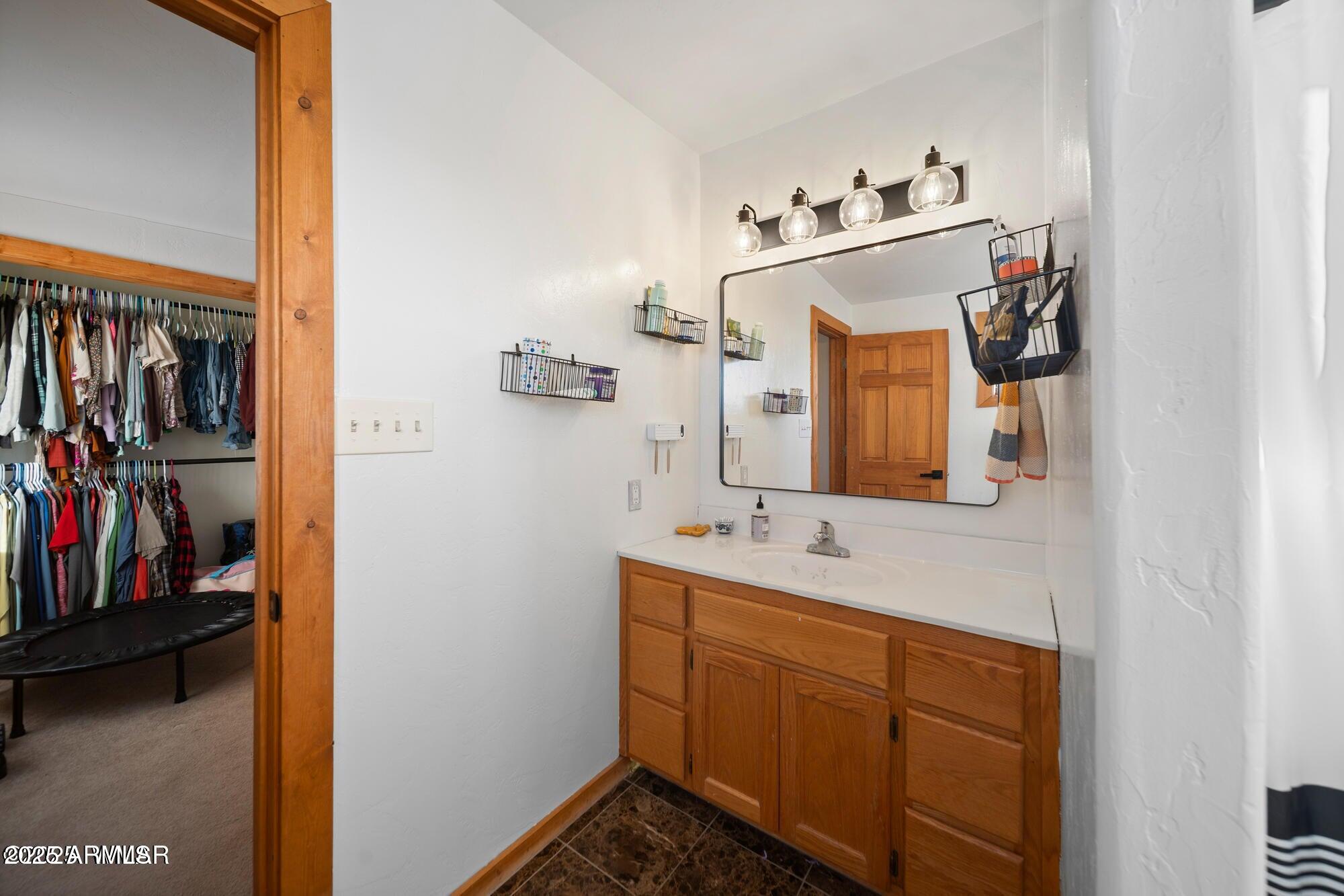 1923 Creekside Circle Show Low, AZ 85901 - Photo 50 of 71 a en suite bathroom with a sink and mirror