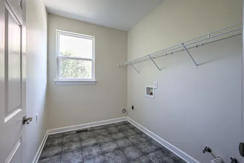 a view of a big room with windows and chandelier fan