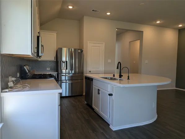 a kitchen with stainless steel appliances granite countertop a sink a stove and a refrigerator