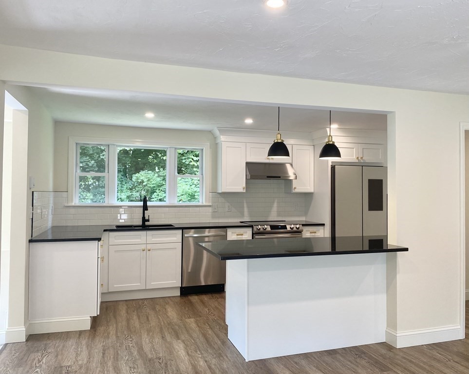 5 Wellesley Avenue Worcester, MA 01605 - Photo 13 of 31 a kitchen with stainless steel appliances granite countertop white cabinets and window