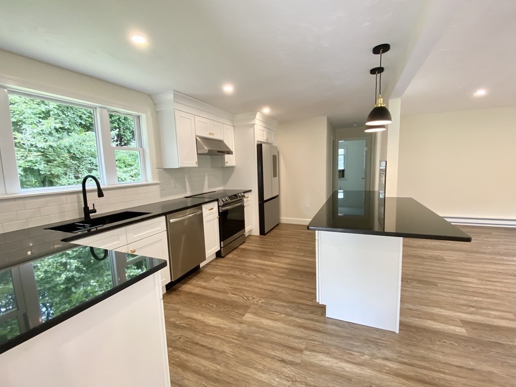 5 Wellesley Avenue Worcester, MA 01605 - Photo 7 of 31 a kitchen with stainless steel appliances granite countertop a sink and a wooden floors