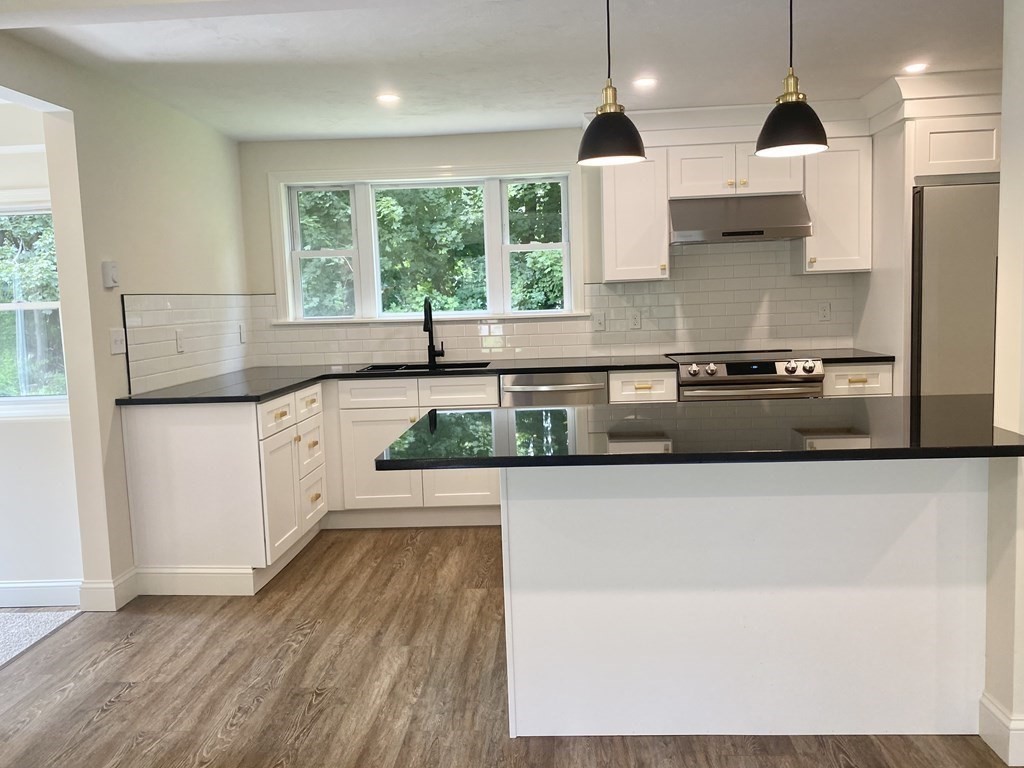 5 Wellesley Avenue Worcester, MA 01605 - Photo 8 of 31 a kitchen with stainless steel appliances granite countertop a sink a stove and a wooden floors