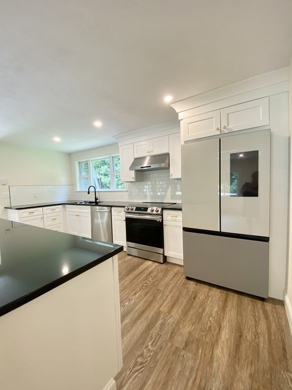 5 Wellesley Avenue Worcester, MA 01605 - Photo 9 of 31 a kitchen with stainless steel appliances granite countertop a sink and a stove top oven