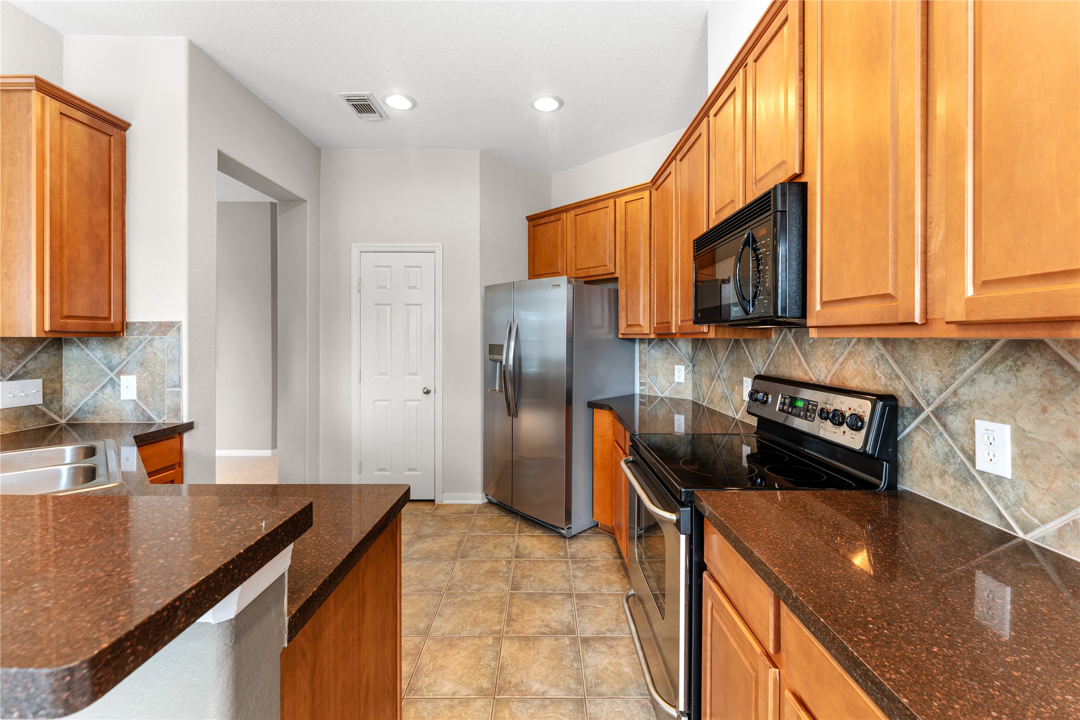3214 Falcon Trail Drive Spring, TX 77373 - Photo 12 of 29 a kitchen with stainless steel appliances granite countertop a sink a stove and a refrigerator